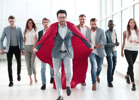 businessman in a red cloak heads the business team. goal concept
