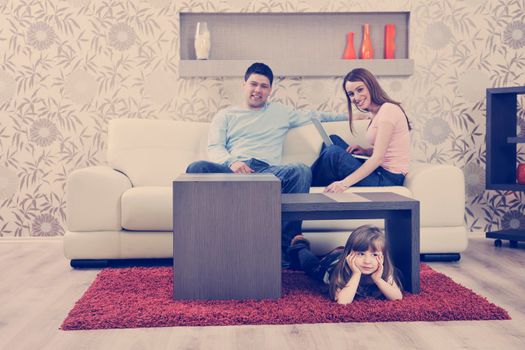 happy youg family relaxing in modern livingroom at home