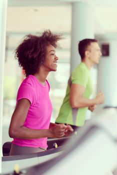 young people exercisinng a cardio on treadmill running machine in modern gym