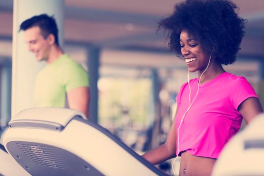 young people exercisinng a cardio on treadmill running machine in modern gym