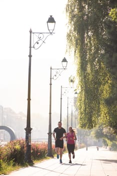 urban sports, healthy young couple jogging  in the city at sunny morning