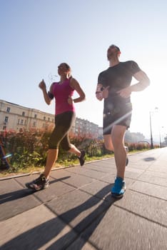 urban sports, healthy young couple jogging  in the city at sunny morning