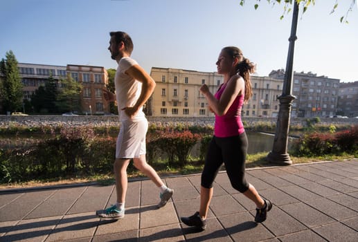 urban sports, healthy young couple jogging  in the city at sunny morning