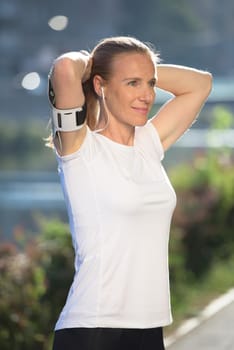 portrait of jogging woman before running  on early morning with sunrise in background