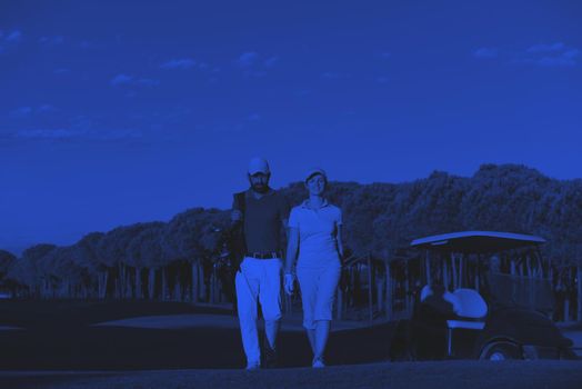 portrait of happy young  golfers couple on golf course duo tone