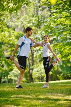 young health couple doing stretching exercise relaxing and warm up after jogging and running in park