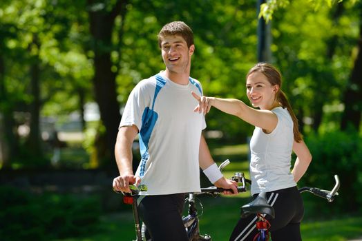 Happy couple riding bicycle outdoors, health lifestyle fun love romance concept