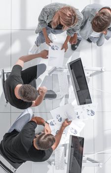 Businesswomen and businessmen using laptop and digital tablet while working on business plan.