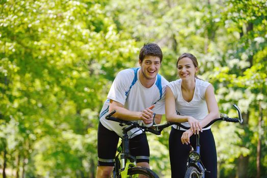 Happy couple riding bicycle outdoors, health lifestyle fun love romance concept