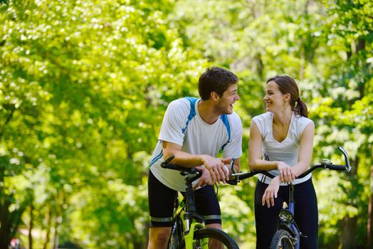 Happy couple riding bicycle outdoors, health lifestyle fun love romance concept