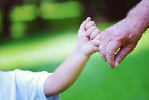 happy grandfather and child have fun and play in park