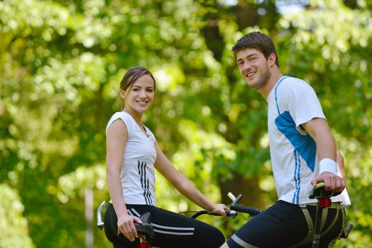 Happy couple riding bicycle outdoors, health lifestyle fun love romance concept