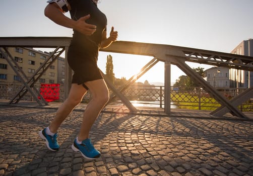 young sporty man jogging across the bridge at sunny morning in the city