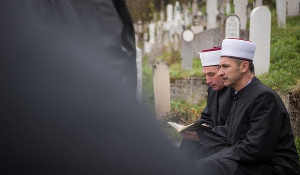 quran holy book reading by imam  on islamic funeral with white thumb stones graweyard background