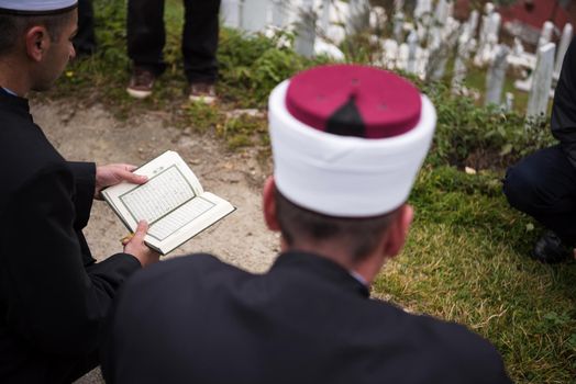 quran holy book reading by imam  on islamic funeral with white thumb stones graweyard background