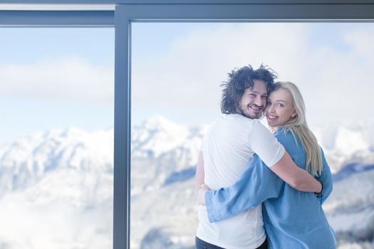 romantic happy young couple enjoying morning coffee by the window on cold winter day at home