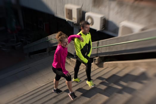 healthy young  couple jogging on steps  at early morning