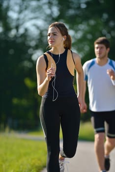 Young couple jogging in park at morning. Health and fitness concept