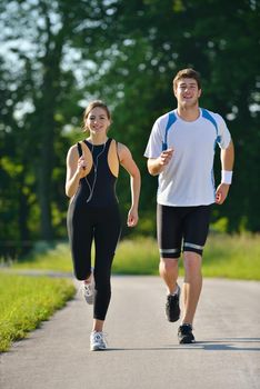 Young couple jogging in park at morning. Health and fitness concept