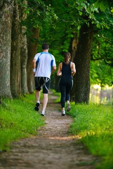 Young couple jogging in park at morning. Health and fitness.