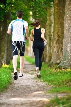 Young couple jogging in park at morning. Health and fitness.