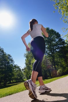 Young beautiful  woman jogging on morning at  park. Woman in sport outdoors health concept