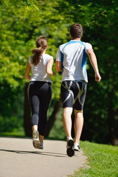 Young couple jogging in park at morning. Health and fitness.