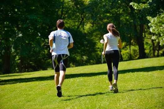 Young couple jogging in park at morning. Health and fitness.