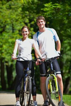 Happy couple riding bicycle outdoors, health lifestyle fun love romance concept