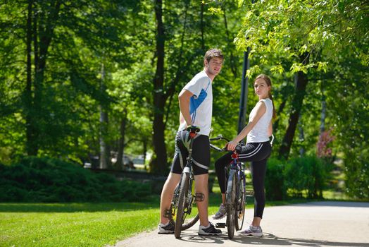 Happy couple riding bicycle outdoors, health lifestyle fun love romance concept