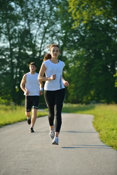 Young couple jogging in park at morning. Health and fitness.