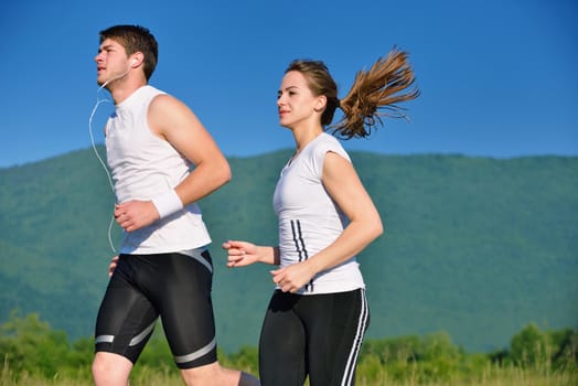 Young couple jogging in park at morning. Health and fitness.