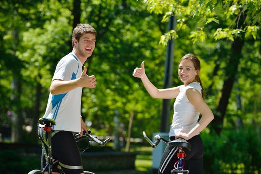 Happy couple riding bicycle outdoors, health lifestyle fun love romance concept