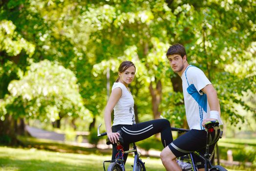 Happy couple riding bicycle outdoors, health lifestyle fun love romance concept