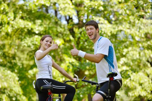 Happy couple riding bicycle outdoors, health lifestyle fun love romance concept