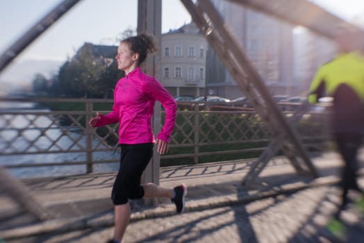 healthy young  couple jogging in the city  at early morning with sunrise in background