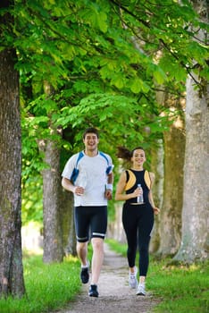 Young couple jogging in park at morning. Health and fitness.