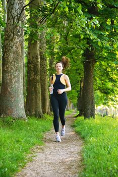 Young beautiful  woman jogging on morning at  park. Woman in sport outdoors health concept
