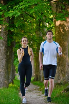 Young couple jogging in park at morning. Health and fitness.