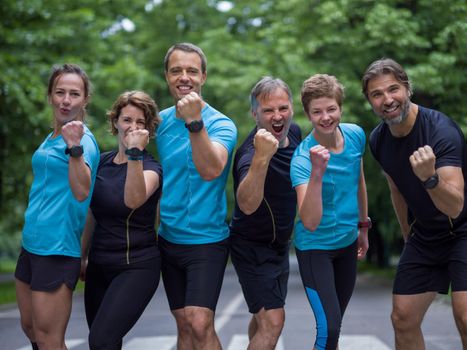 portrait of a group healthy people jogging in city park, runners team on morning training