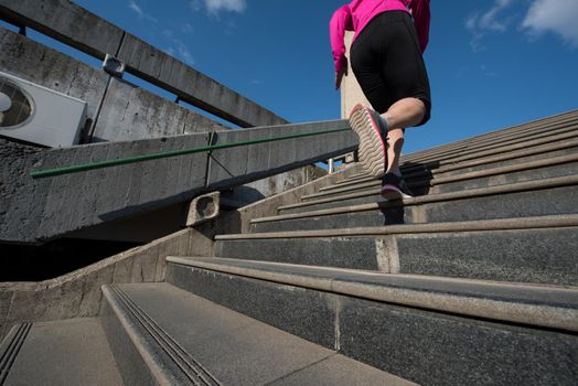 sporty woman running onsteps at early morning jogging