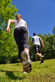 Young couple jogging in park at morning. Health and fitness concept