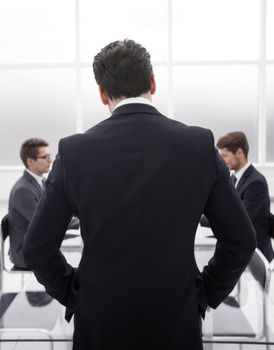 rear view.businessman standing in the conference room.business concept