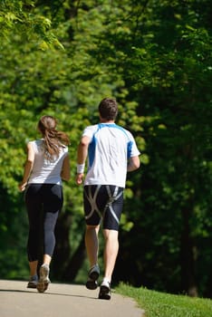 Young couple jogging in park at morning. Health and fitness concept