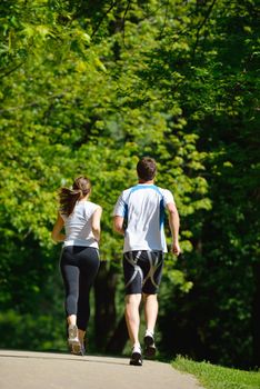 Young couple jogging in park at morning. Health and fitness.