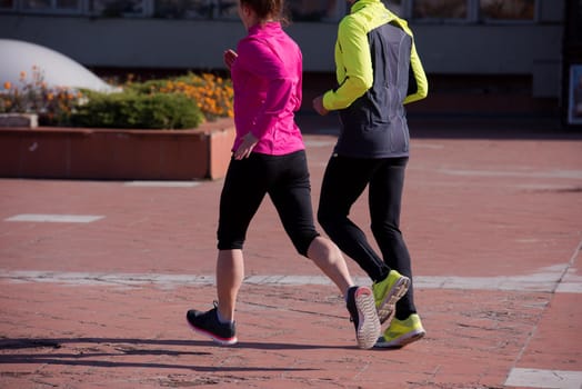 healthy young  couple jogging in the city  at early morning with sunrise in background