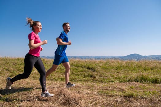 couple jogging in a healthy lifestyle on a fresh mountain air  at beautiful sunny summer nature