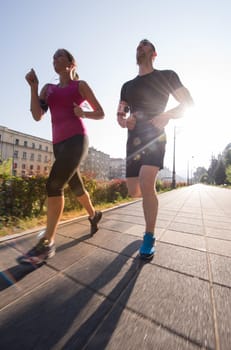 urban sports, healthy young couple jogging  in the city at sunny morning