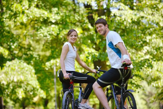 Happy couple riding bicycle outdoors, health lifestyle fun love romance concept