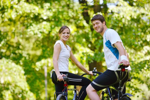 Happy couple riding bicycle outdoors, health lifestyle fun love romance concept